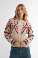 Saco tejido con diseño geométrico estilo inca, en tonos beige, rosa y marrón. Presenta cuello redondo, cierre frontal con botones y puños acanalados.