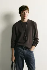 Sweater de punto color beige con textura tipo waffle, cuello redondo y mangas largas con acabado en rib.