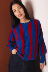 Cárdigan tejido con lurex, a rayas verticales rojas y azules, con cuello redondo y cierre frontal con botones.