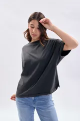 Remera de manga corta con efecto de lavado desgastado en color gris oscuro, de corte holgado y cuello redondo.