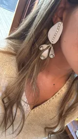 Aros colgantes plateados con forma de lágrima y detalles de strass.