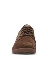 Zapato casual de mujer Hush Puppies modelo Rojam, confeccionado en cuero gamuzado color marrón. Presenta cierre mediante cordones al tono, suela de goma flexible y detalle de logo metálico en el lateral.
