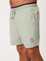 Short de baño Polanco modelo Loraz, color coral, con cintura elástica, cordón ajustable blanco y negro, bolsillos laterales y pequeño logo circular estampado en la pierna.