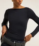 Blusa de manga larga color bordó de Cortelle, confeccionada en poliamida con escote bote y diseño regular.