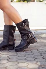 Bota de cuero negra, de caña media, con hebillas y suela track.