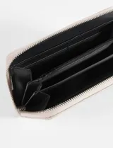 Billetera roja de cuero sintético con diseño rectangular, decorada con tachas metálicas plateadas en los bordes y logo metálico central.