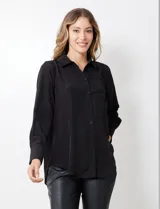 Camisa de satén color violeta, con cuello clásico, cierre frontal con botones, manga larga con puños anchos abotonados y bolsillo aplicado en el pecho.
