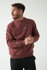 Buzo color gris con estampado de letras en la espalda, cuello redondo y puños en las mangas.