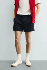 Shorts de corte sastrero confeccionados en tejido de piqué elástico, con cierre frontal de cremallera y gancho metálico oculto, y bolsillos laterales.