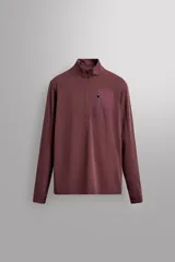Sudadera técnica color vino tinto, de manga larga, con cuello subido y cierre frontal de cremallera. Presenta un bolsillo frontal con cierre de cremallera oculta en costura y detalle de logo estampado. El tejido tiene estructura waffle en el interior.