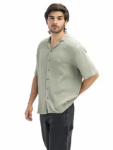 Camisa de manga corta confeccionada en tela tetra de algodón, con cuello cubano y cierre frontal de botones. Presenta un corte suelto y relajado, ideal para un estilo casual y fresco.