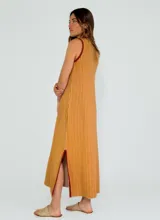 Vestido midi de punto con diseño a rayas verticales en tonos mostaza y blanco, con cuello redondo y sisas contrastadas en color bordó. Presenta aberturas laterales en el ruedo con detalles en color bordó.