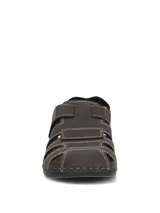 Sandalias de cuero color marrón oscuro con diseño tipo huarache o romano, costuras visibles en tono contrastante y cierre con tira ajustable de velcro en el empeine.