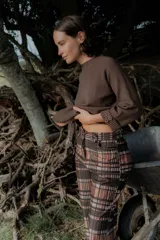 Pantalón de corte recto con estampado a cuadros en tonos marrones y rosados. Presenta una pretina elástica para mayor comodidad y está confeccionado en una tela acanalada con caída suave.