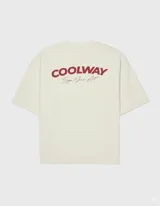 Camiseta color crema de algodón con cuello redondo y mangas cortas. Presenta un estampado pequeño con el logo de la marca en el frente.