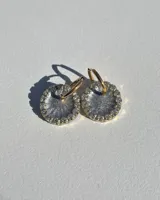 Aros colgantes dorados con dije circular de resina color turquesa, bordeado con strass. El arito es de acero quirúrgico.