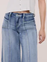 Jean wide leg de tiro alto en denim azul claro, con calce ajustado en la cadera, costuras verticales frontales y bolsillos estilo carpintero.