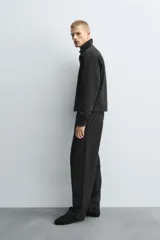 Pantalón regular fit color marrón oscuro, confeccionado en tejido con viscosa. Cuenta con cintura elástica, bolsillos delanteros y detalle de bolsillos traseros de vivo. El cierre frontal es con cremallera y botón.