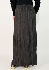 Pollera larga de corte amplio con diseño plisado y estampado abstracto en tonos beige y gris. Presenta cintura elástica para un ajuste cómodo.