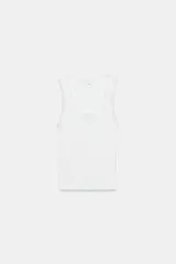 Musculosa de algodón color negro, con escote redondo y tiras anchas. Presenta detalles de encaje negro en los bordes y aplicación de perlas pequeñas alrededor del escote y los hombros.