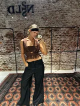 Top de microtul color marrón con escote profundo, diseño cruzado y faja en la cintura con detalle de volados en el ruedo. Presenta una estructura de doble capa para mayor opacidad y ajuste regulable en la espalda.