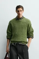 Jersey de punto con estructura de torzal y efecto jaspeado, de corte relajado, cuello redondo y manga larga con acabados en rib.