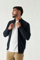 Campera tejida color verde militar, con cuello alto, puños y logo bordado.