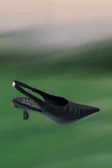 Zapato destalonado de cuero vacuno con textura de reptil, color negro, con punta fina y taco bajo.