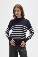 Polera de punto con diseño a rayas horizontales en contraste, cuello alto y mangas largas con puños ajustados.