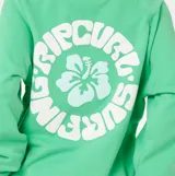Buzo Rip Curl de manga larga ranglán, color verde, con cuello redondo y diseño holgado. Cuenta con un pequeño estampado blanco en el centro del pecho que combina un diseño floral con el logotipo de la marca.