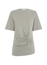 Remera color verde lavado, estilo camiseta, corte asimétrico, cuello redondo, manga corta y detalle fruncido lateral.