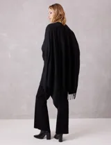 Ruana negra de tejido soft, con detalles de brillos y perlas en los extremos, y terminación con flecos.