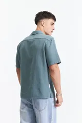 Camisa de manga corta color crema con textura, cuello clásico y calce regular.