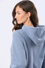 Campera de polar azul con cierre frontal, capucha integrada y bolsillos laterales. Presenta un diseño entallado con logo bordado en el pecho.