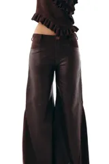 Pantalon de corte wide leg confeccionado en una combinación de cueros ovinos en tonos chocolate, incluyendo paneles de cuero liso, cuero desgastado y gamuza suave. Presenta diseño de cinco bolsillos y cierre frontal.