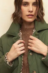 Campera capitoneada color verde militar, con botones veteados, bolsillos laterales con solapa y forro de satén con estampado animal print.