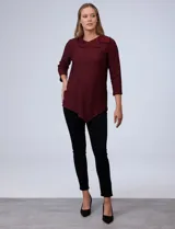 Blusa de tejido piqué con estampado geométrico en tonos negro y bordó. Presenta cuello volcado, mangas tres cuartos y un diseño de ruedo asimétrico.