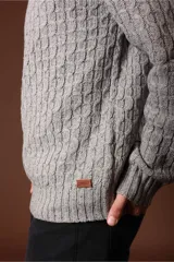 Sweater de punto color gris claro, con cuello redondo y diseño de tejido trenzado.