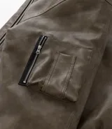 Campera bomber de poliuretano con acabado efecto cuero, cuello redondo, cierre frontal con cremallera, bolsillos delanteros y bolsillo utilitario en la manga. Presenta puños y ruedo elásticos, con forro interior en contraste.