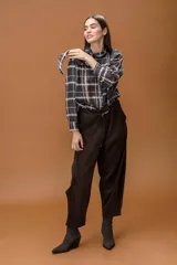 Camisa de manga larga con estampado de cuadros escoceses en tonos oscuros, cuello clásico y cierre frontal abotonado.