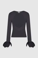 Blusa negra de manga larga con diseño ajustado, escote redondo y detalles de lazos amarrados en los puños.