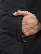 Campera azul marino con cierre frontal, cuello alto y bolsillos laterales con cierre. Tiene un parche rojo con cierre en la manga izquierda y un diseño acolchado en la parte delantera.