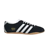 Championes Adidas modelo Tokyo, de diseño retro con exterior de gamuza negra, las icónicas tres tiras laterales en blanco y suela de goma color caramelo. Incluye el logo de la marca y el nombre del modelo en dorado en el lateral.