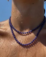 Collar de cuentas de lapislázuli de 6mm con separadores de hilo rojo y cierre de mosquetón dorado.