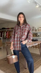 Camisa de manga larga con estampado a cuadros en tonos bordó y gris, de corte oversize y con bolsillos frontales con solapa.