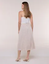 Falda midi evasé de color beige con diseño a rayas horizontales y verticales blancas, cintura alta elastizada y caída fluida.