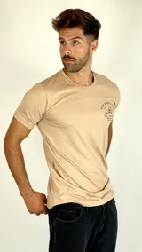 Remera de algodón color beige con cuello redondo y mangas cortas. Presenta un estampado gráfico pequeño en el pecho con la leyenda 'High Spirits Diner' y un dibujo de una calavera.