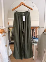 Pantalón palazzo de lino color verde militar, de corte amplio y relajado, con cintura elástica y botón frontal.