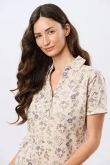 Camisa de algodón de manga corta en tejido jersey, con estampado floral de inspiración retro, cuello camisero y abertura frontal parcial con botones.