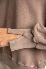 Sweater de algodón peinado con efecto lavado, de corte oversize, cuello redondo y mangas largas con costuras visibles.